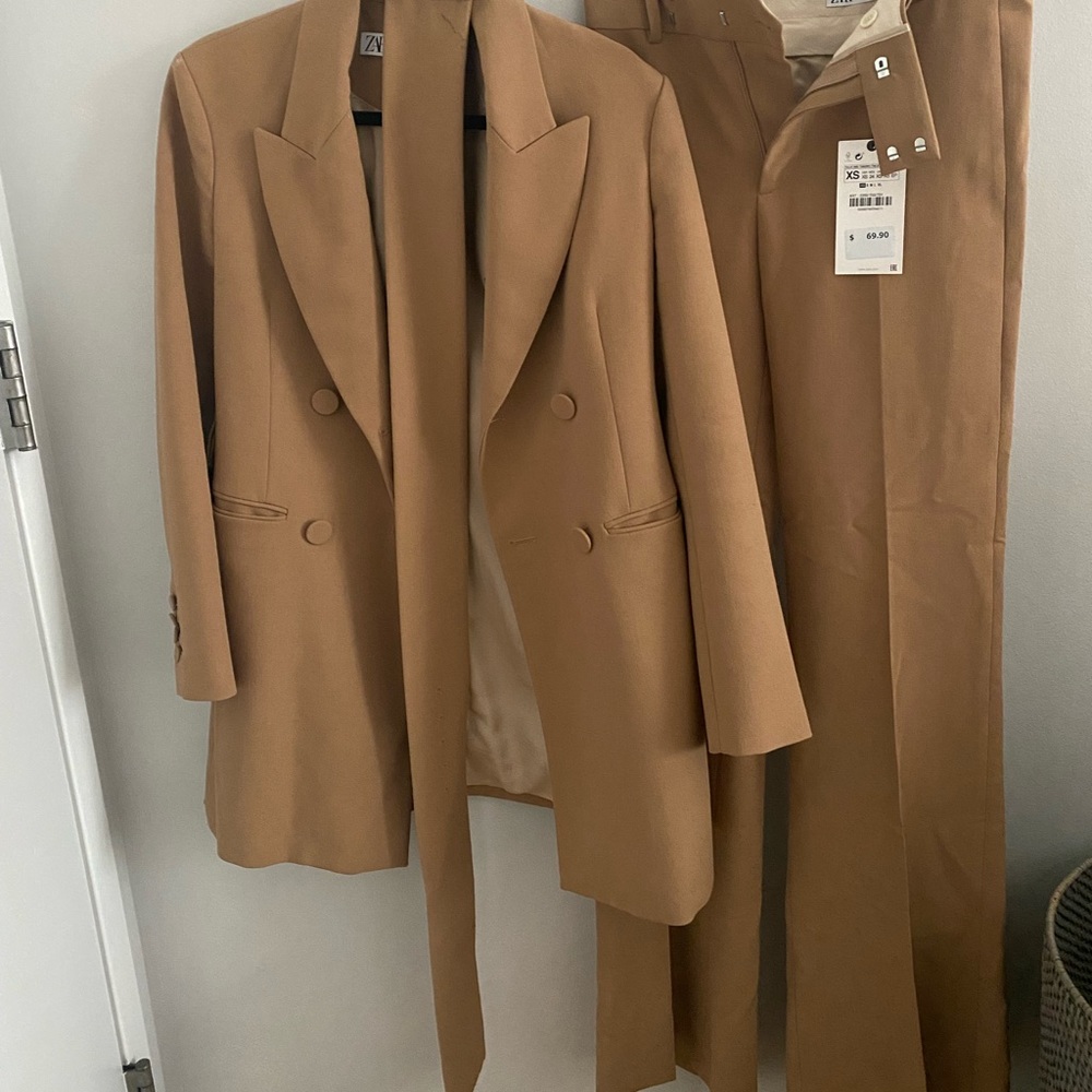 Camel colored suit blazer with belt and flare pant.